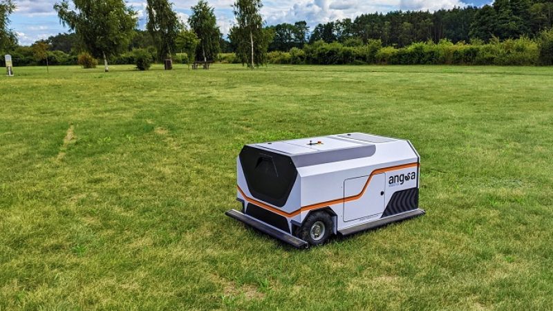 Ein mobiler Roboter reinigt eine Rasenfläche automatisch von Kleinstmüll.